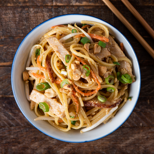 A white and blue bowl of turkey pad thai