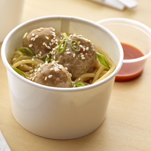 Kung pao meatball noodle bowl in a paper bowl